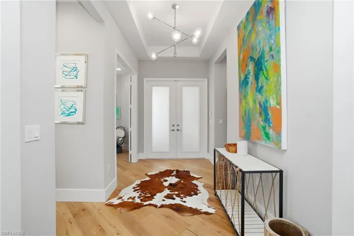 Entryway with french doors and light wood-style floors