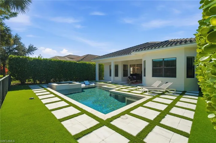 View of swimming pool with a fenced backyard, a patio, and a pool with connected hot tub