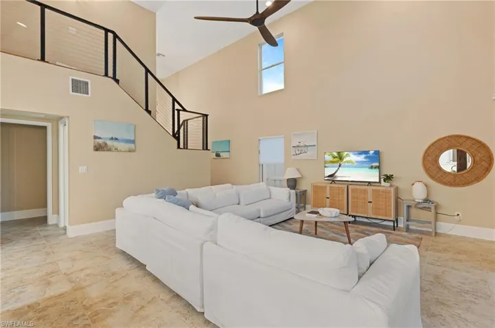 Living room featuring high vaulted ceiling and ceiling fan