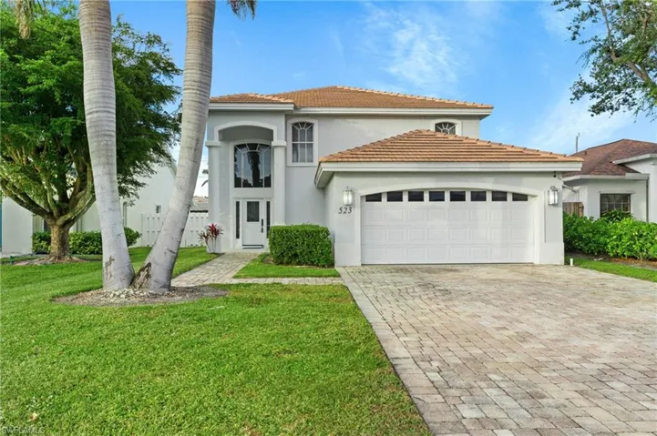 Mediterranean / spanish-style house with a front yard and a garage