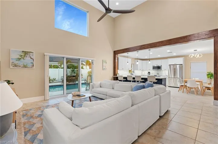Tiled living room with a towering ceiling and ceiling fan