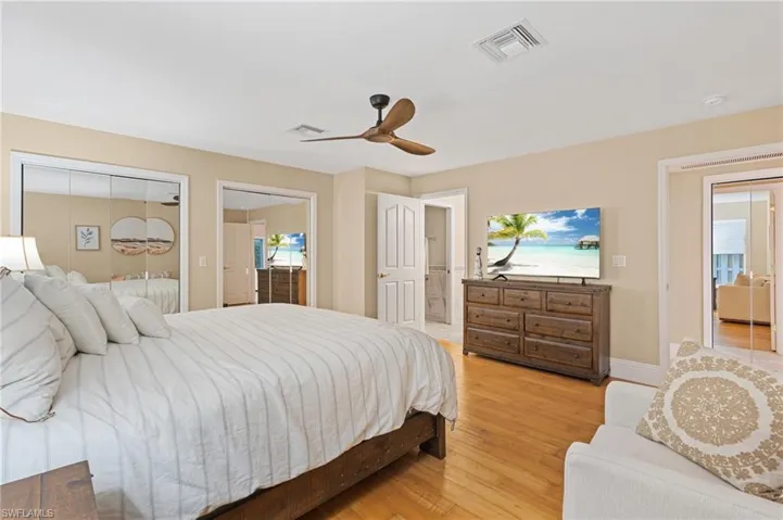 Bedroom featuring ceiling fan, light wood-type flooring, and multiple closets