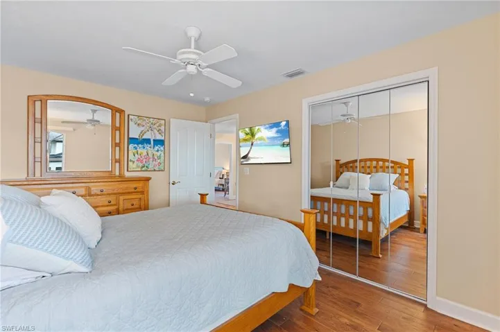 Bedroom with hardwood / wood-style floors, a closet, and ceiling fan