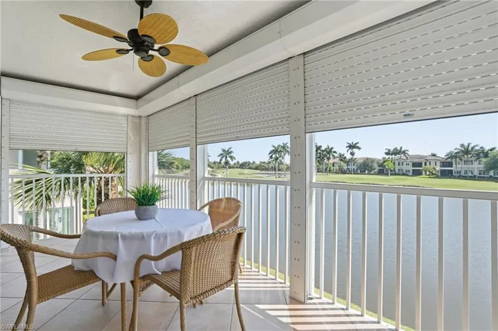 Enclosed patio featuring a ceiling fan, light-toned tile flooring, and accordion hurricane shutters