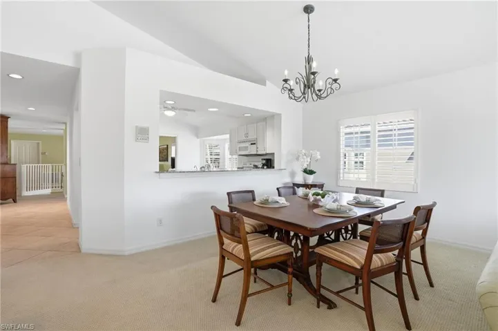 Dining area featuring an ornate chandelier and plantation shutters