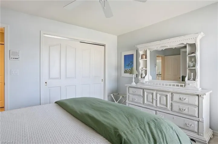 Panel doors with brass hardware, ceiling fan, and light gray wall paint