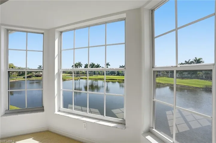 Large pane windows showcasing a water feature and distant tropical landscaping