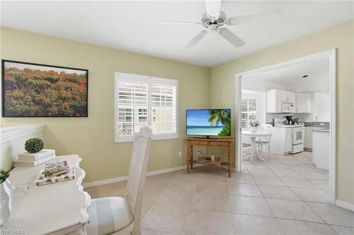 Neutral-toned ceramic tile flooring extending into the bright kitchen