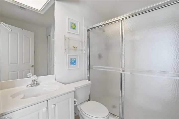 Bathroom featuring a white vanity with integrated sink, chrome faucet, and white cabinetry