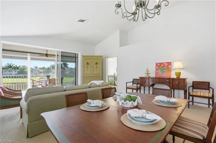 Vaulted ceilings complement the interior, featuring a screened patio overlooking a waterfront canal