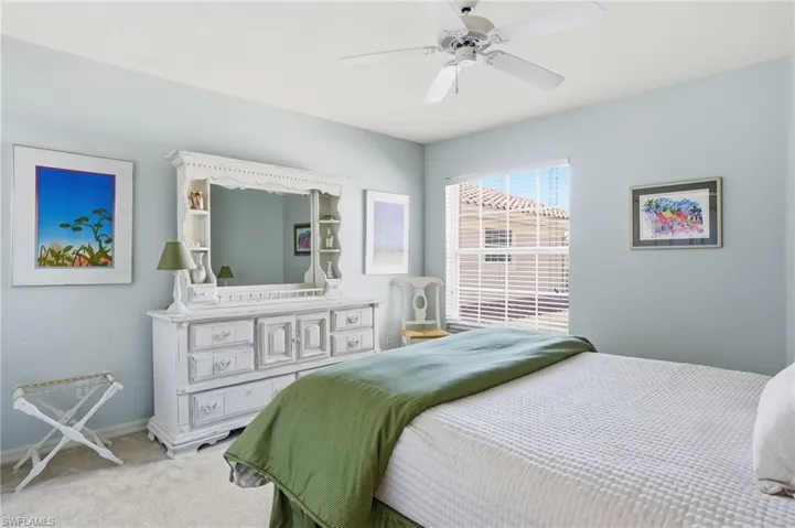 Bedroom featuring a window with horizontal blinds, overhead ceiling fan, and light blue wall color