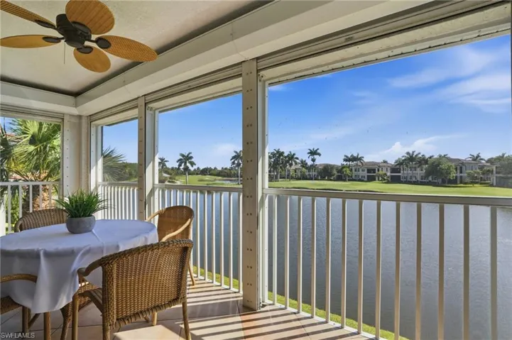Screened lanai featuring a ceiling fan, tiled flooring, and a water vista with golf course beyond