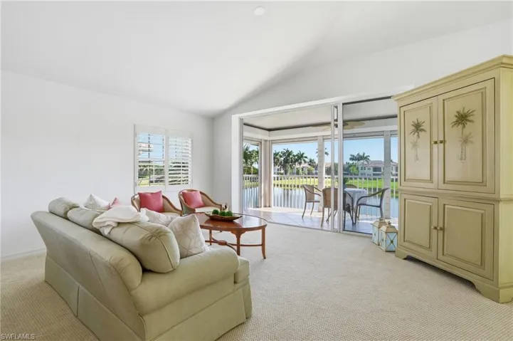 Interior living area featuring vaulted ceilings and light-colored carpeting