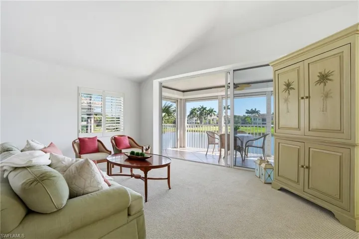 Interior space featuring vaulted ceilings, a window with white louvered shutters, and light-toned wall-to-wall carpeting