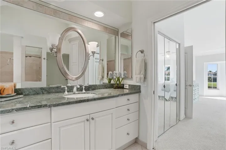 Bathroom vanity featuring a green stone countertop, undermount sink, and brushed nickel fixtures