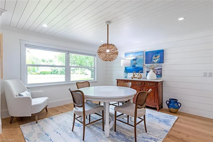 Dining space featuring light hardwood / wood-style flooring, crown molding, and wood ceiling