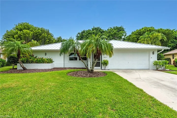 Single story home with a garage and a front yard