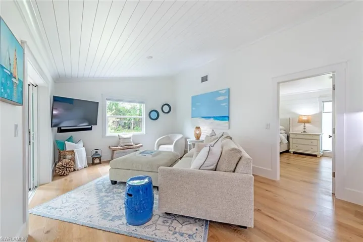 Living room with vaulted ceiling, wood ceiling, and light hardwood / wood-style flooring