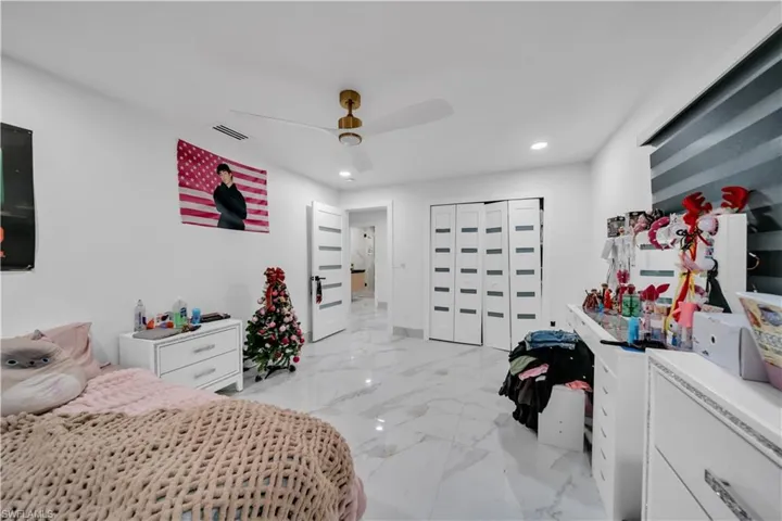 Bedroom with light marble finish flooring, a closet, a ceiling fan, and recessed lighting