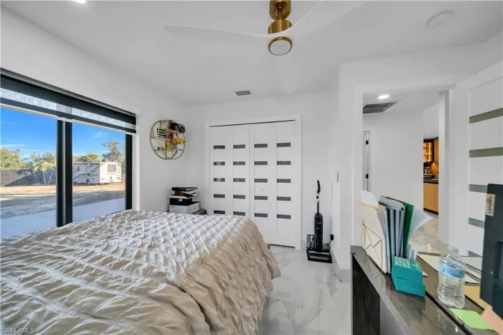 Bedroom with recessed lighting, a closet, access to outside, and light marble finish floors