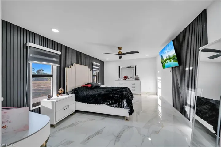 Bedroom featuring recessed lighting, a ceiling fan, and light marble finish flooring