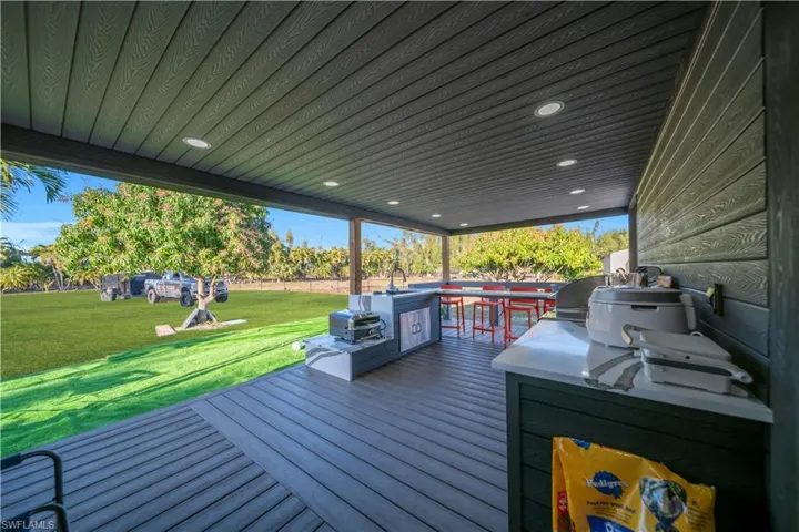 Deck featuring a lawn, grilling area, and outdoor dining area