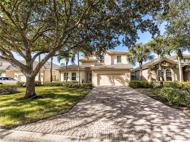 View of front of house with a front lawn, decorative driveway, stucco siding, an attached two-car garage, and a tiled roof