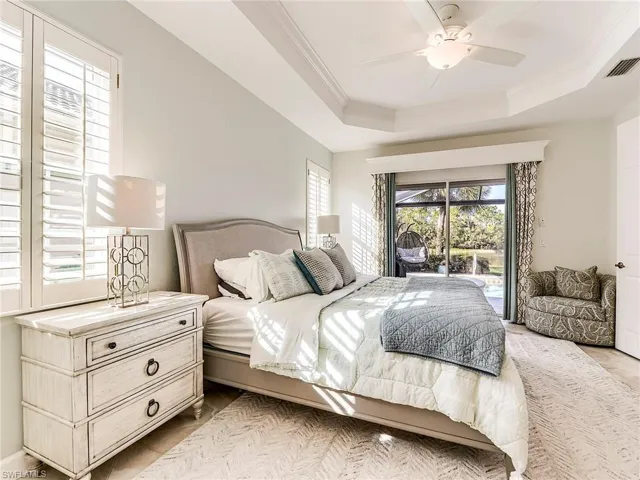 Bedroom featuring access to outside, ceiling fan, ornamental molding, and a tray ceiling