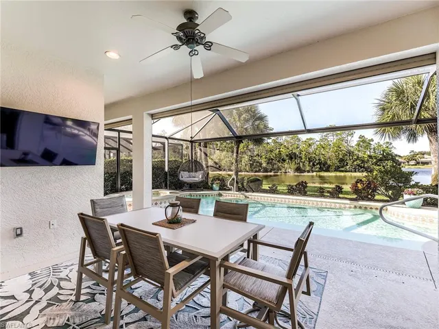 View of patio / terrace with panoramic screen enclosure, an outdoor pool, and outdoor dining space