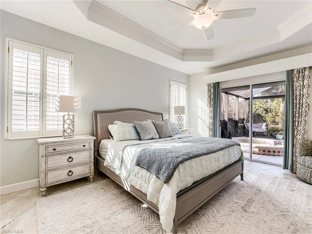 Bedroom with access to outside, crown molding, a ceiling fan, and a tray ceiling