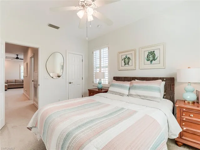 Carpeted bedroom featuring ceiling fan