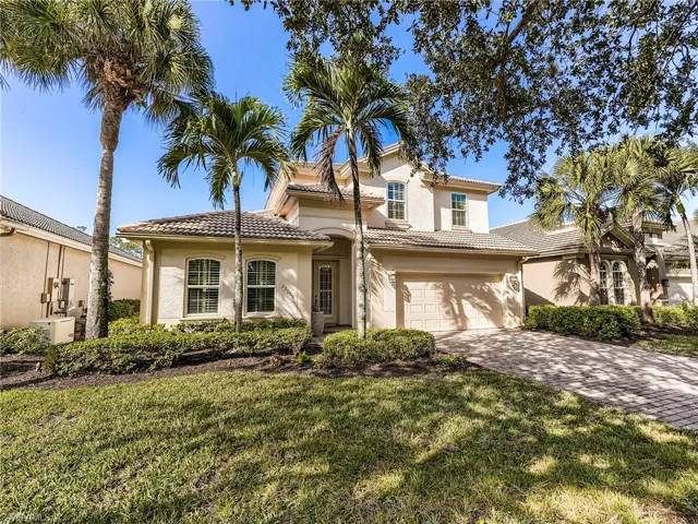 Mediterranean / spanish-style home with stucco siding, decorative driveway, a front lawn, a tile roof, and a garage