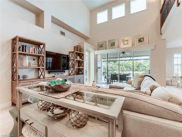 Living area with plenty of natural light, light tile patterned floors, and a towering ceiling