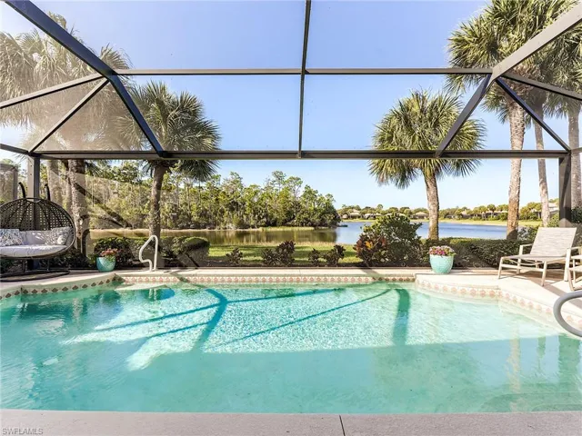 Swimming pool with a lanai, a water view, and a patio