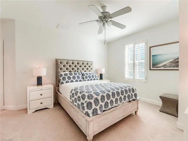 Bedroom with a ceiling fan and carpet