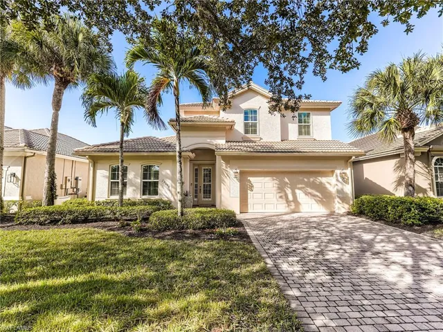 Mediterranean / spanish home featuring decorative driveway, a garage, stucco siding, a front yard, and a tiled roof