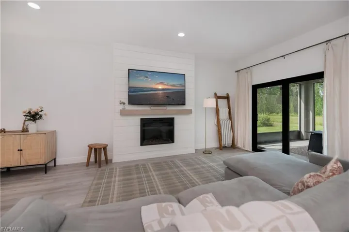 Living area with recessed lighting, wood finished floors, and a fireplace