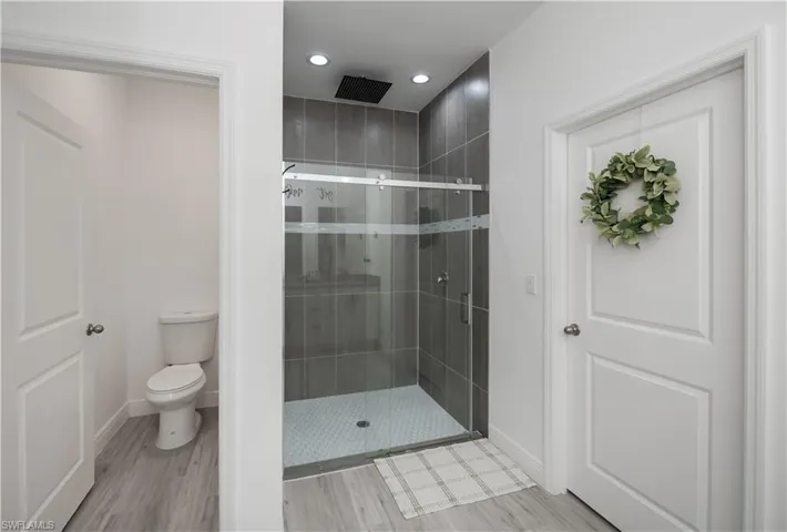 Bathroom with a stall shower, light wood-style floors, and recessed lighting