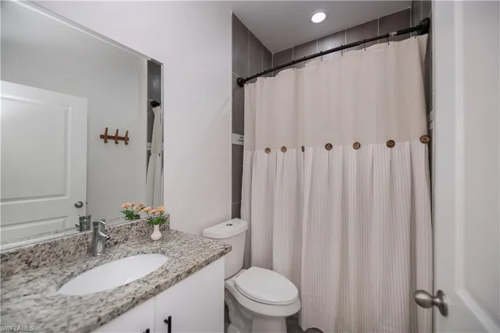 Bathroom with vanity, a shower with curtain, and recessed lighting
