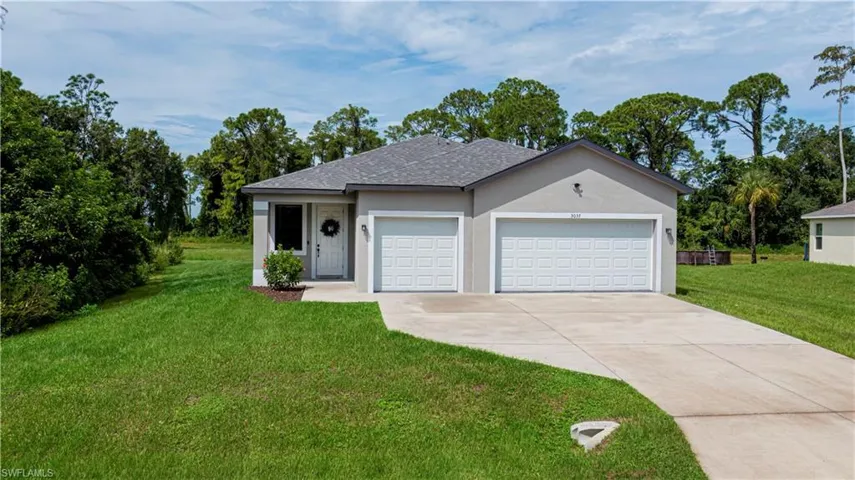 Ranch-style house featuring a front lawn, a garage, stucco siding, concrete driveway, and roof with shingles