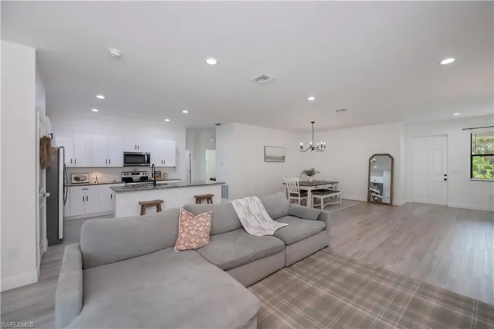 Living room with light wood-style flooring and a chandelier