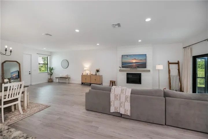 Living room featuring a fireplace, light wood finished floors, and hanging lights