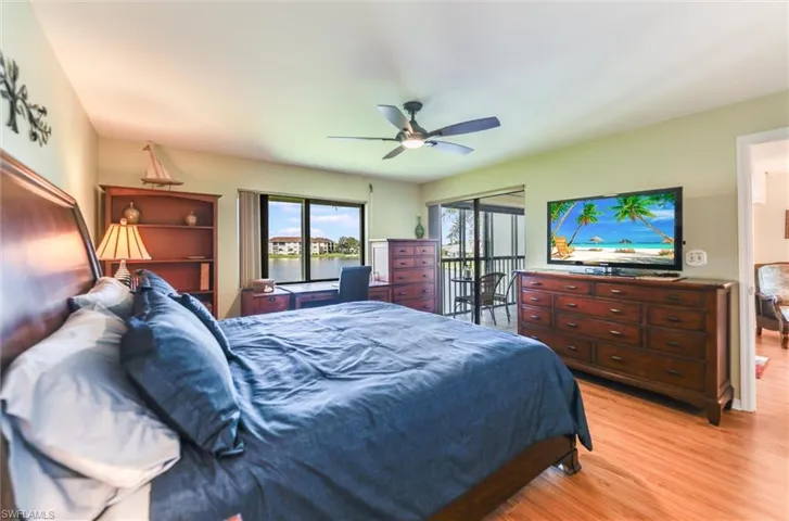 Bedroom with access to exterior, light wood-type flooring, and a ceiling fan