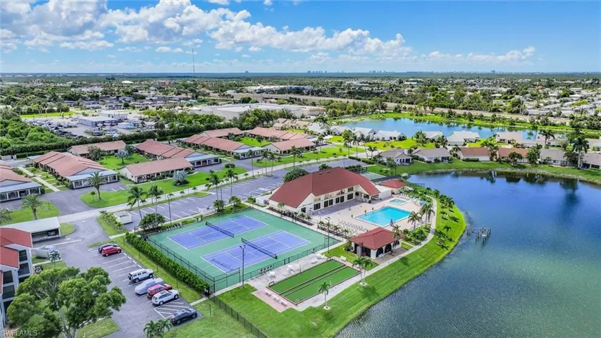 Aerial view of residential area featuring a large body of water and a pool area