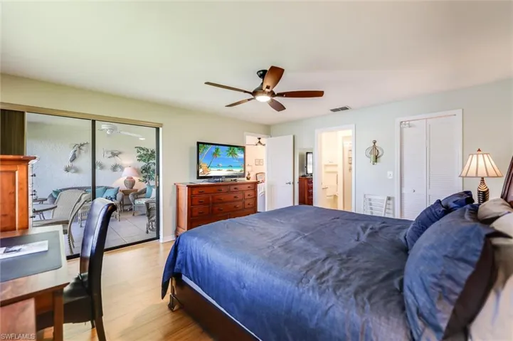 Bedroom with wood finished floors, ceiling fan, and two closets