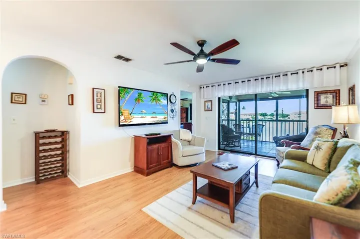 Living room with light wood-type flooring and a ceiling fan