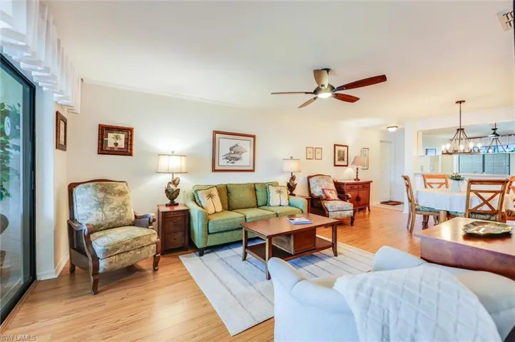 Living room featuring light wood-type flooring, a chandelier, and ceiling fan