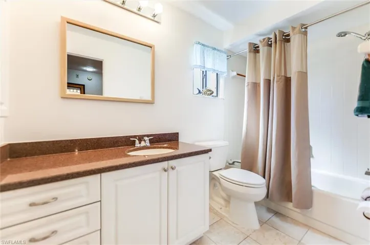 Bathroom featuring shower / tub combo, vanity, and light tile patterned floors