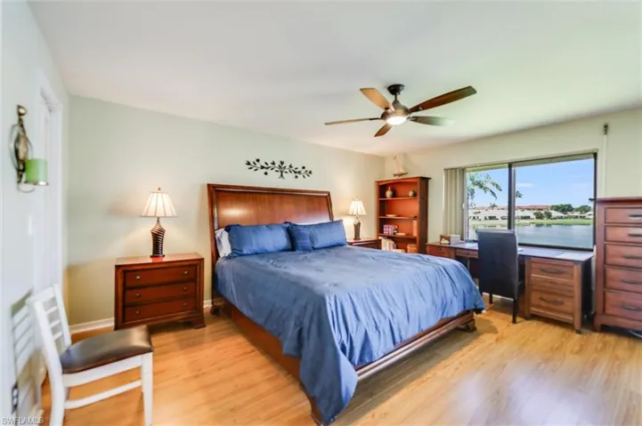 Bedroom with a water view, light wood finished floors, and ceiling fan