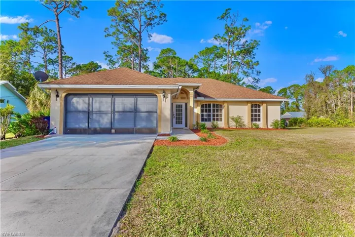 Single story home featuring a garage and a front yard